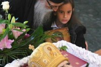 Мала Уна са иконом у руци нијемо стоји поред ковчега свога кума Амфилохија